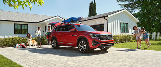 A family surrounding a parked 2024 VW Atlas.